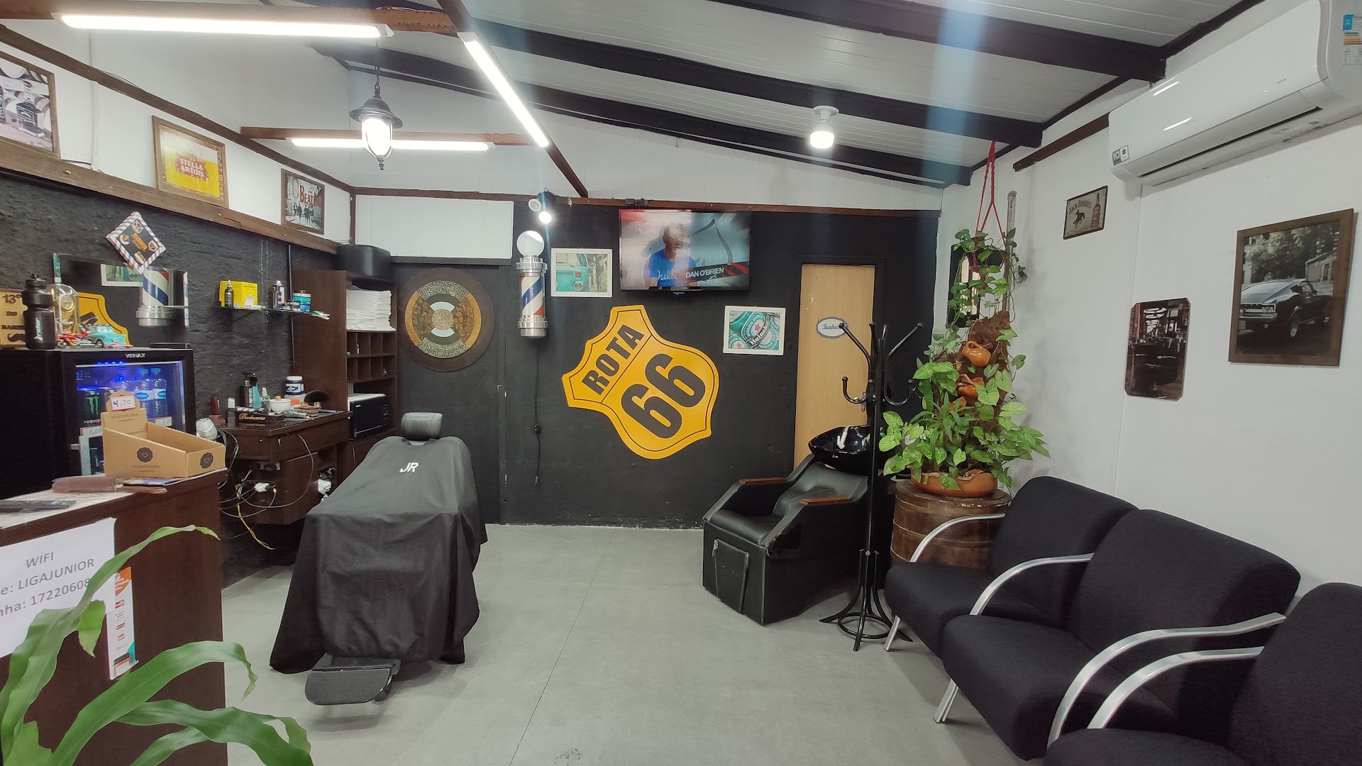 Interior da Barbearia Dinastia, com a parede verde e a placa Route 66